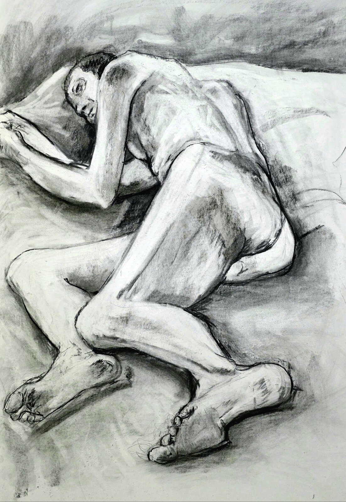 A charcoal life drawing of a reclining figure.